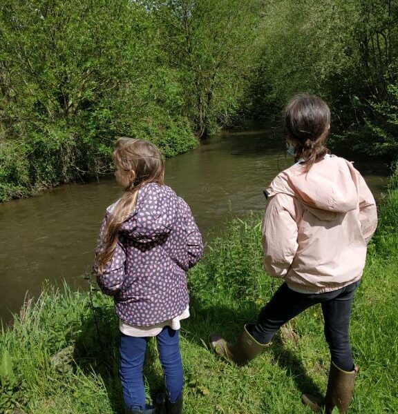 Deux petites filles observent la rivière à la ferme Les Berges Rient en Mayenne